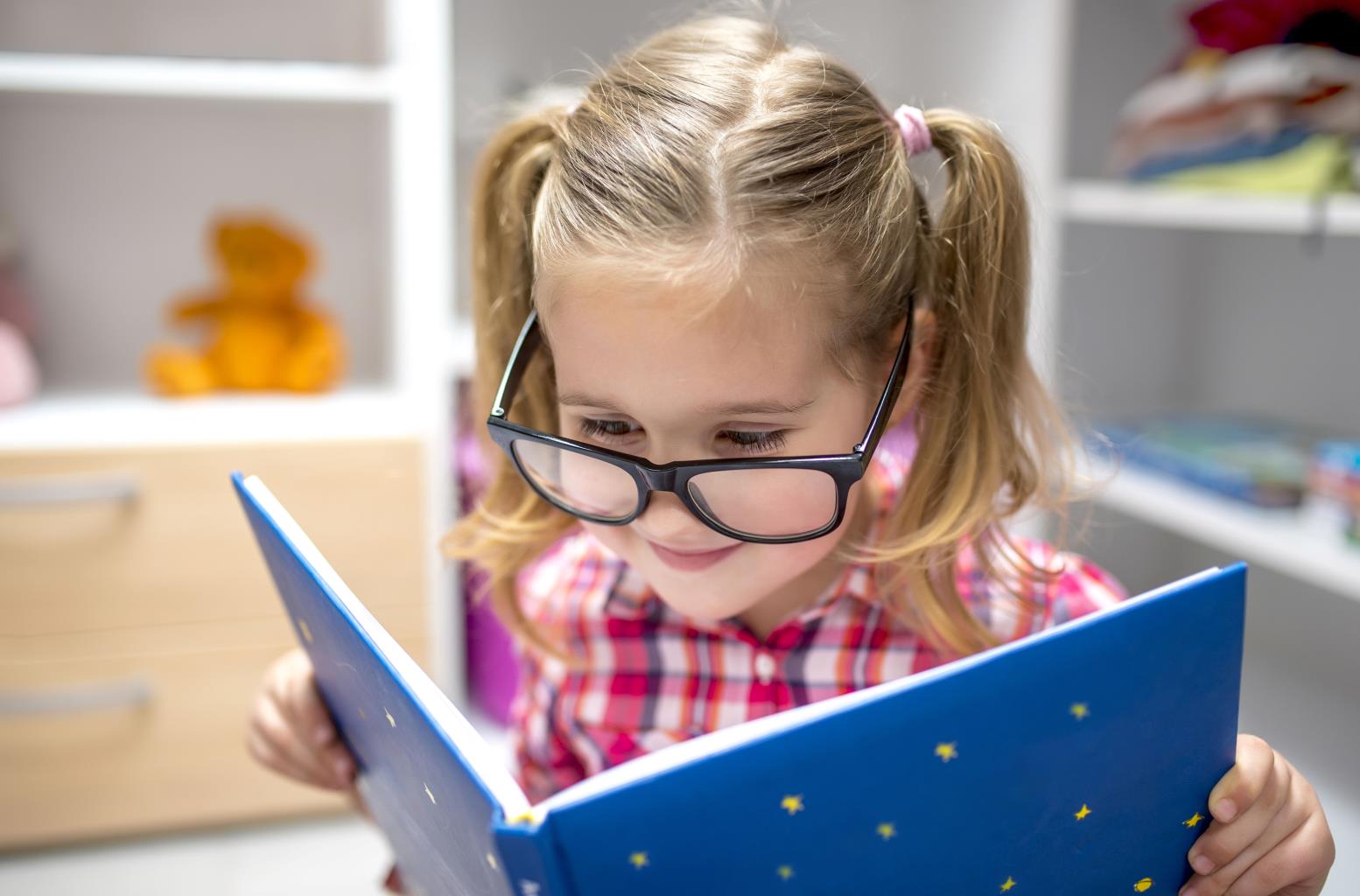adorable_female_child_with_glasses_reading_interesting_book.jpg