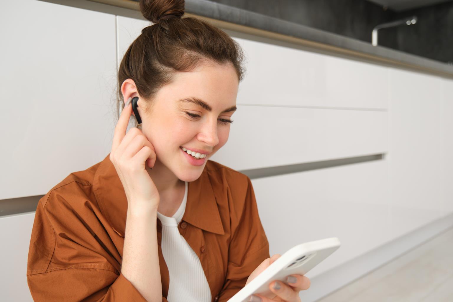 portrait_woman_enjoying_watching_videos_smartphone_with_wireless_earphones_girl_listening.jpg