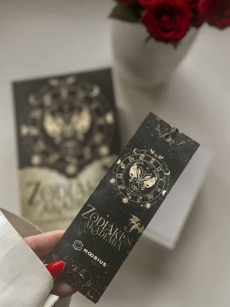 A Könyvvásáron nem tudtam ellenállni, így muszáj volt megvennem a Zodiákus Akadémiához tökéletesen passzoló könyvjelzőt is!🙈

Az első rész engem bár nem teljesen olyan volt, mint amire számítottam, t